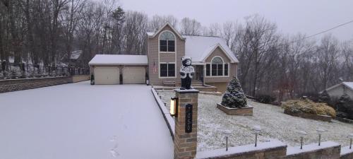 a house with a statue of a skeleton in the snow at Luxury getaway in woods, Jacuzzi, Hot Tub, Pool in Bushkill