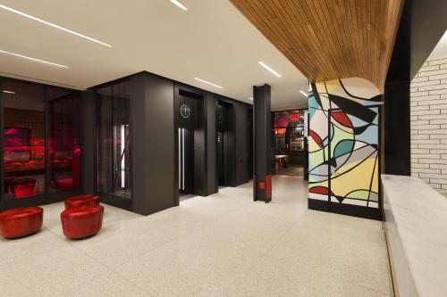 a lobby with red stools and a painting on the wall at Pod 39 in New York