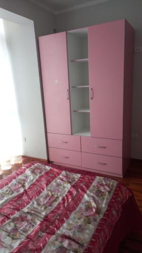 ein rosafarbenes Schlafzimmer mit einem Bett und einer Kommode in der Unterkunft AyacuchoDepa in Ayacucho