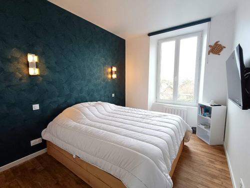 - une chambre dotée d'un lit avec un mur vert dans l'établissement Appartement rénové au centre de Trébeurden, 400m de la plage, proche commerces - FR-1-368-407, à Trébeurden