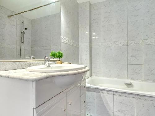 uma casa de banho branca com um lavatório e uma banheira em Apartamento L'Escala, 2 dormitorios, 6 personas - ES-89-130 em Torroella de Montgrí