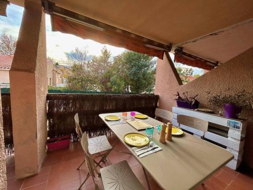 une table et des chaises assises sur une terrasse dans l'établissement Superbe T2 Rez-de-Jardin Proche Plage avec Terrasse et Parkings - Argelès-sur-Mer - FR-1-388-220, à Argelès-sur-Mer