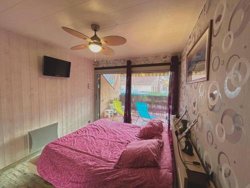 - une chambre avec un lit rose et un ventilateur de plafond dans l'établissement Superbe T2 Rez-de-Jardin Proche Plage avec Terrasse et Parkings - Argelès-sur-Mer - FR-1-388-220, à Argelès-sur-Mer