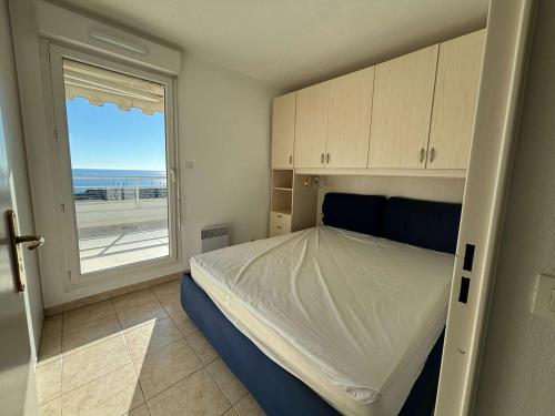 une chambre avec un lit avec vue sur l'océan dans l'établissement Appartement 3 pièces proche plage à Cannes la Bocca - FR-1-609-95, à Cannes