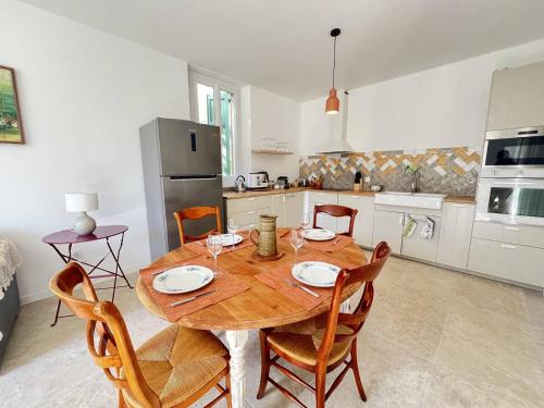 une cuisine avec une table et des chaises en bois dans l'établissement Appartement calme avec jardin à 50m de la plage, WiFi, parking et équipements de qualité - FR-1-770-26, à La Ciotat