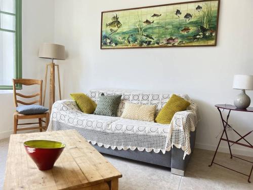 un salon avec un canapé et une table dans l'établissement Appartement calme avec jardin à 50m de la plage, WiFi, parking et équipements de qualité - FR-1-770-26, à La Ciotat