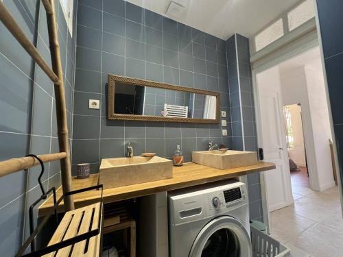 une salle de bain avec deux lavabos et une machine à laver dans l'établissement Appartement calme avec jardin à 50m de la plage, WiFi, parking et équipements de qualité - FR-1-770-26, à La Ciotat