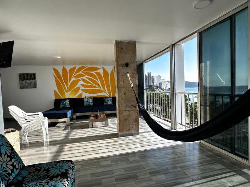 a living room with a hammock in a house at Vista increíble Chirama Rodadero in Santa Marta