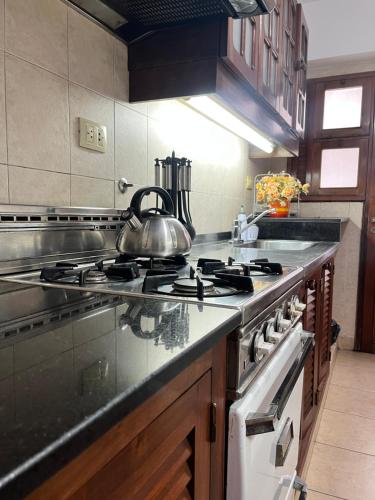a kitchen with a stove with a tea kettle on it at Departamento Céntrico San Miguel de Tucuman in San Miguel de Tucumán