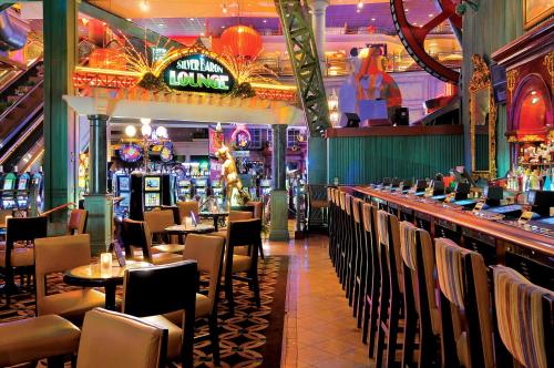 a restaurant with tables and chairs and a bar at Silver Legacy Reno, A Caesars Destination in Reno