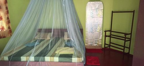 a bedroom with a bed with a mosquito net at Ravana - Beach CABANAS in Hikkaduwa