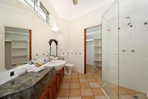 ein Badezimmer mit zwei Waschbecken, einer Dusche und einem WC in der Unterkunft Solander House - 5 Bedrooms by the Beach in Port Douglas