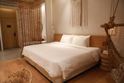a bedroom with a large bed with white sheets at Manli Hotel Shanghai Pudong Airport Branch -Provide free shuttle buses to Pudong Airport and Disneyland in Shanghai