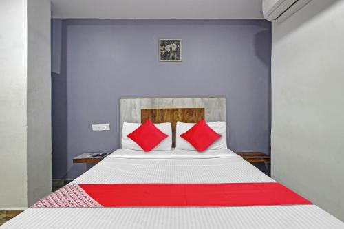 a bedroom with a bed with red pillows at Hotel O Sri Sai Regency in Hyderabad