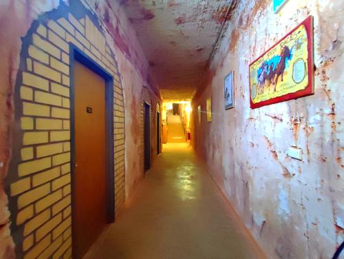 an empty hallway in a building with a brick wall at Radeka Downunder Underground Motel in Coober Pedy
