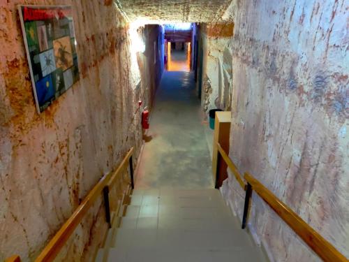 a long hallway with stairs in an old building at Radeka Downunder Underground Motel in Coober Pedy