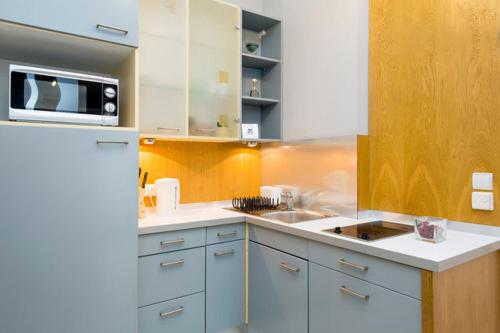 a kitchen with a white refrigerator and a microwave at Apartament Amaryllis in Krakow