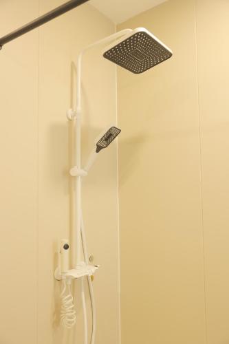 a shower with a shower head in a bathroom at 三亚豪晟珠崖民宿(海棠湾免税城店) in Sanya