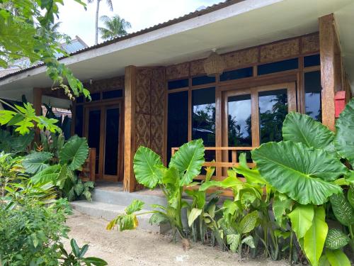 a house with large green plants in front of it at Dee Siargaonon Homestay in General Luna