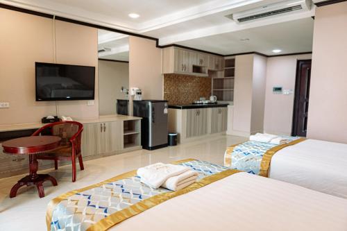 a hotel room with two beds and a kitchen at VANHSENG BOUTIQUE VIENTIANE HOTEL in Vientiane