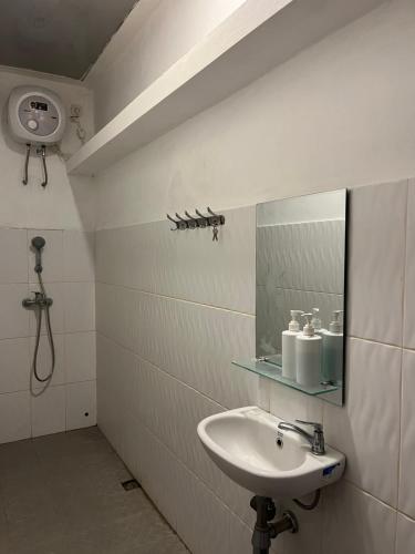 a bathroom with a sink and a mirror at Attanaya Malioboro Suites Yogyakarta in Sentool