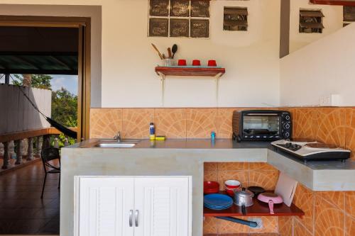 a kitchen with a counter with a sink and a microwave at Baan Kiao in Haad Yao