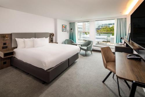 a hotel room with a large bed and a desk at Holiday Inn Milton Keynes Central by IHG in Milton Keynes