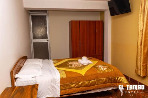 una camera con un letto con una coperta gialla e bianca di HOTEL EL TAMBO a Chachapoyas