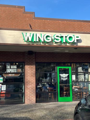 a wine shop with green doors in a brick building at Columbus Motor Inn in Seattle