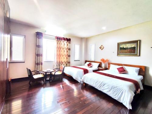 Habitación de hotel con 2 camas y mesa en Ngọc Phương Anh Homestay Huế en Hue