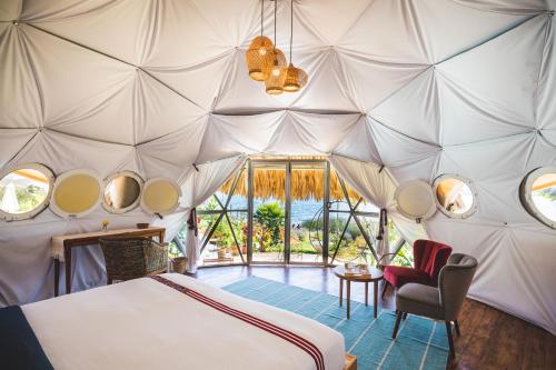 - une chambre avec un lit dans une tente dans l'établissement Kula Maya Boutique Hotel and Spa, à San Marcos La Laguna