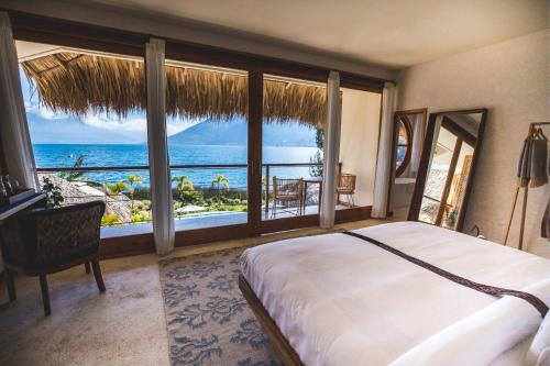 a bedroom with a bed and a view of the ocean at Kula Maya Boutique Hotel and Spa in San Marcos La Laguna