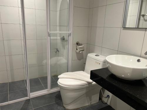 a bathroom with a shower and a toilet and a sink at Chambers suites in Kuala Lumpur