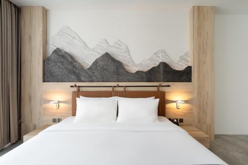 a bedroom with a large white bed with two lights at Timberton Resort Khaoyai in Ban Tha Maprang