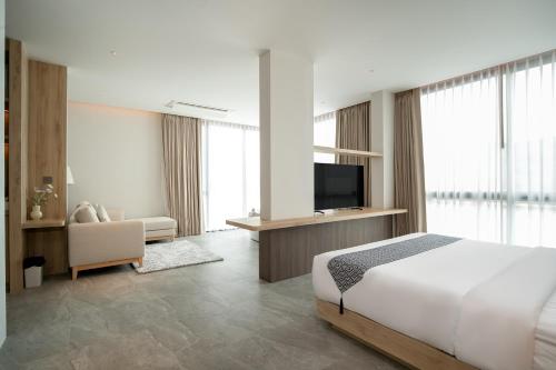 a hotel room with a bed and a television at Timberton Resort Khaoyai in Ban Tha Maprang