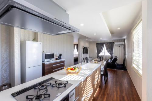 a kitchen with a stove and a counter top at パプリカホテルです in Kisarazu