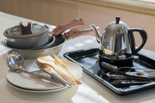 a kitchen counter with a tray of utensils and a tea kettle at パプリカホテルです in Kisarazu