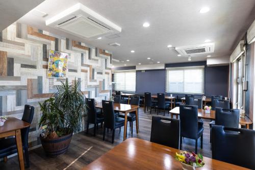 a dining room with wooden tables and chairs at パプリカホテルです in Kisarazu