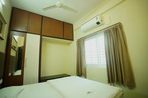 a small room with two beds and a window at Sri Govindham Home Stay in Tirupati