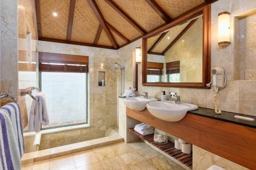 uma casa de banho com 2 lavatórios e um espelho grande em Far Pavilion A - Stylish Villa with Tropical Views em Port Douglas