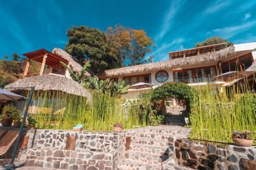 a house with a stone wall and a fence at Kula Maya Boutique Hotel and Spa in San Marcos La Laguna