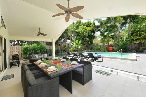 a patio with a table and chairs and a pool at The Red Anchor in Port Douglas