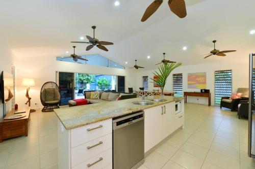 a kitchen with a counter top and a living room at The Red Anchor in Port Douglas