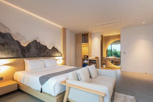 a bedroom with a king sized bed and a couch at Timberton Resort Khaoyai in Ban Tha Maprang