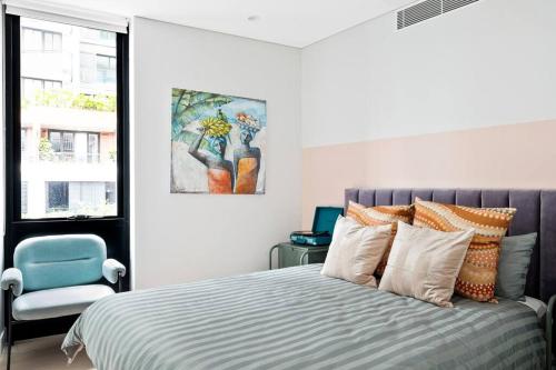 a bedroom with a bed and a blue chair at The Rosella Suite—Boutique Living in Sydney