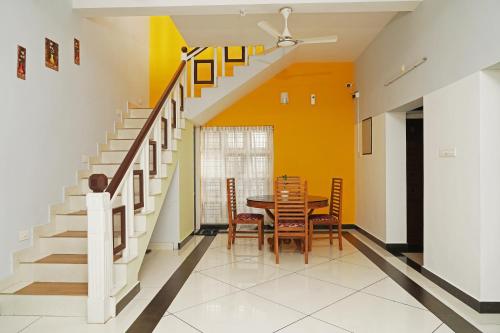 a dining room with a table and a yellow wall at ORANGE VALLEY TOWN RESIDENCY in Trivandrum