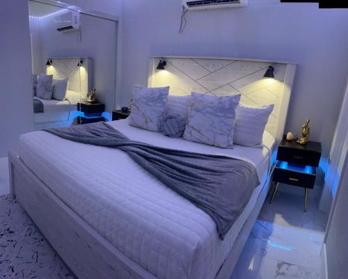 a bedroom with a large white bed with blue lighting at Fantastic Suite in Las Vegas