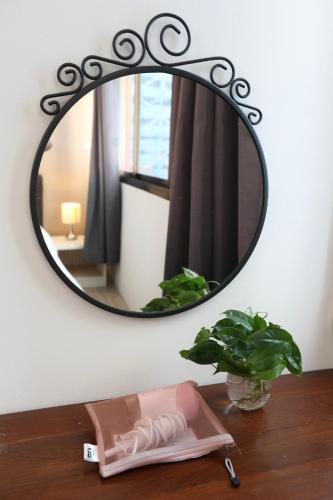 a mirror on a wall above a wooden table at Studio F Sukhumvit in Bangkok