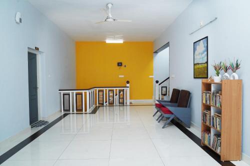 a hallway with a staircase and a yellow wall at ORANGE VALLEY TOWN RESIDENCY in Trivandrum