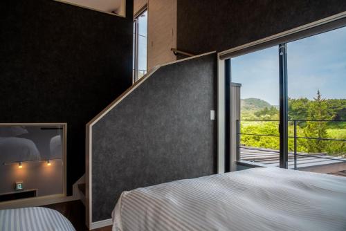 ein Schlafzimmer mit einem Bett und einem großen Fenster in der Unterkunft Retreat Villa Aym - Vacation STAY 18153v in Minamiboso
